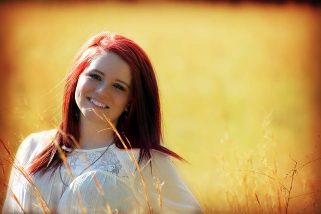 A teenage girl smiling outdoors.
